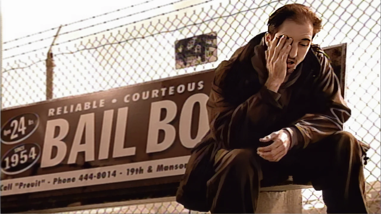 A man sitting at a desolate bus stop alone.